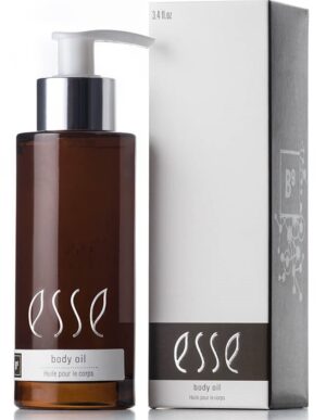 A 3.4 fluid ounce bottle of "Esse Body Oil" with a brown hue and a white pump dispenser is displayed next to its coordinating white and grey packaging box, which also features the product name and relevant information.