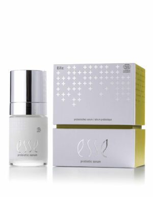 The Esse Probiotic Serum with a silver cap is shown beside its minimalist white and yellow box, both featuring silver-embossed branding.