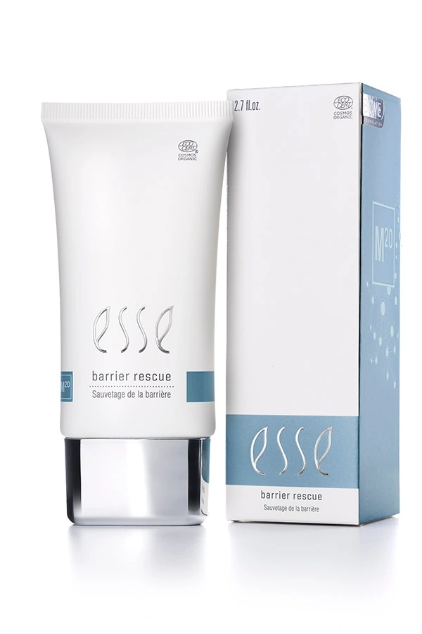 A white 2.7 fl oz tube labeled “Esse Barrier Rescue” stands beside its matching box, both adorned with blue and silver accents and featuring the description “Sauvetege de la barrière.”.